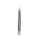 Een Hay Patroon Kaars Zand Donkerblauw van Hay, met gedurfde donkerblauwe diagonale strepen, staat verticaal tegen een witte achtergrond.