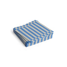 De Hay Pattern Papieren Servetten Grijs Blauw Streep 33/33 van Hay zijn gestapeld afgebeeld op een witte achtergrond. Deze stijlvolle, FSC gecertificeerde servetten hebben een grijs blauw streep ontwerp voor een eco-vriendelijke touch.