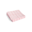 Een stapel Hay Pattern Papieren Servetten Lichtroze Rood Grid 33/33 van Hay, netjes gerangschikt op een witte achtergrond.