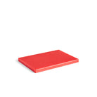 Een gesloten, rechthoekig rood boek of notitieblok ligt plat op een wit oppervlak en lijkt qua vorm en kleur op de Hay Slice Snijplank Rood 20/30 van Hay.