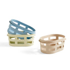 Drie pastelkleurige rechthoekige Hay manden, waaronder de Hay Wasmand Geel, zijn gestapeld met open rasterzijden. Hun charmante ontwerp van Hay steekt af tegen een effen witte achtergrond.