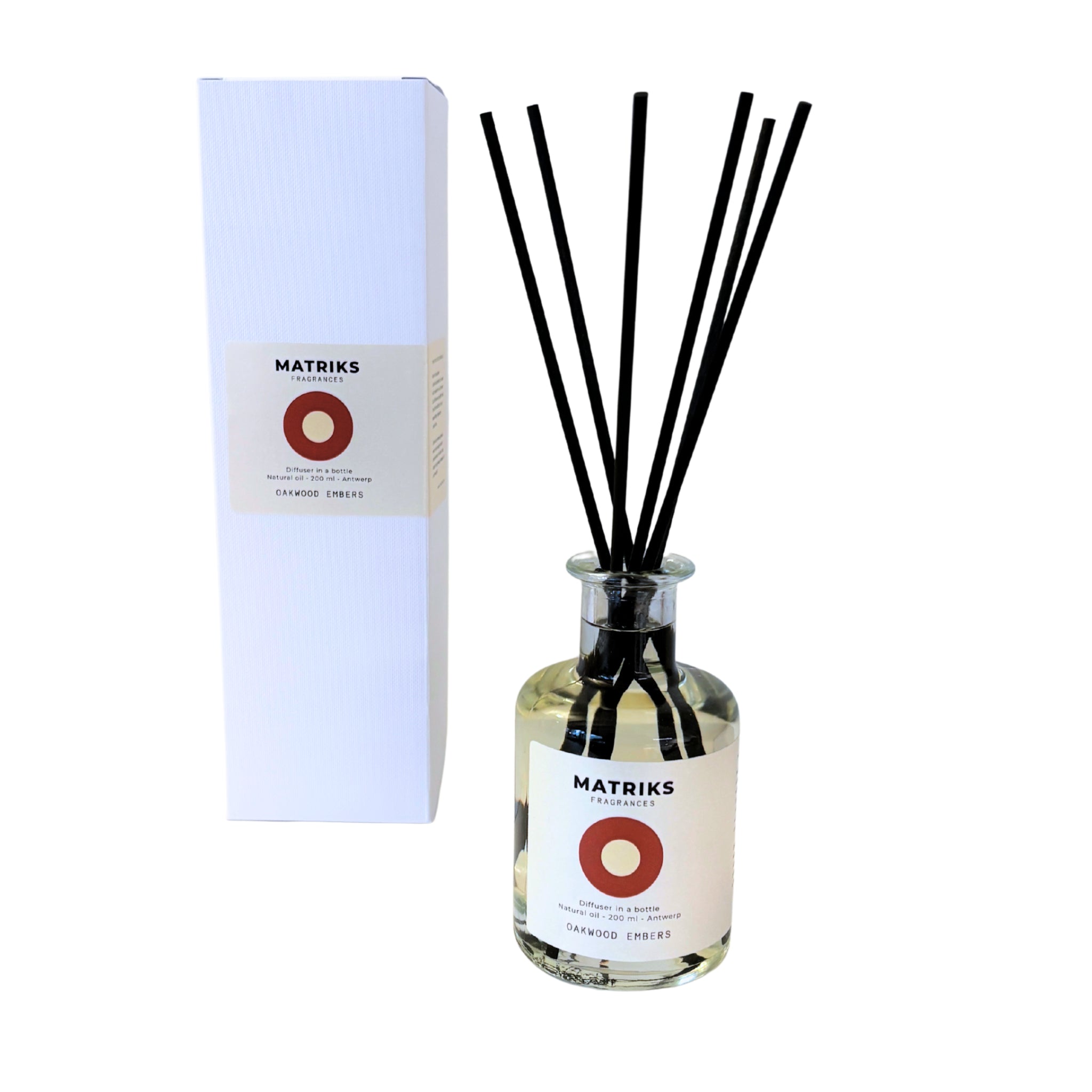 De Matriks Fragrances-geurverspreider Oakwood Embers 200 ml bestaat uit een heldere glazen fles met zwarte rietstokjes, gevuld met de lichte Oakwood Embers-vloeistof, en wordt geleverd in een hoge witte doos; beide zijn voorzien van het hoogwaardige Matriks Fragrances-label.