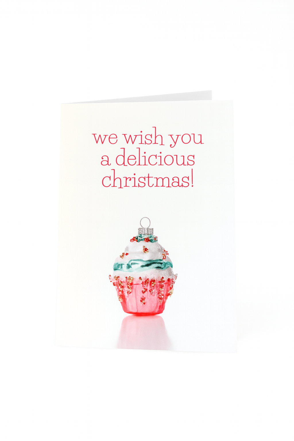 De Matriks Kerstkaart We Wish You a Delicious Christmas! van Matriks heeft een uniek ornament met daarop een cupcake met wit glazuur en rode hagelslag. De feestelijke rode tekst erboven luidt: "We wish you a delicious Christmas!.