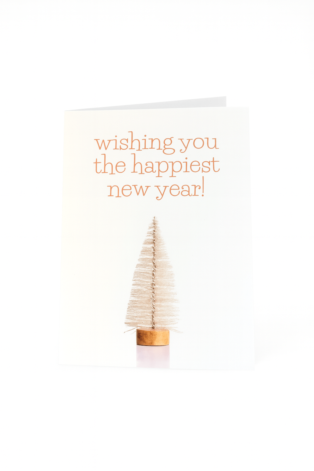 De Matriks Nieuwjaarskaart Wishing You the Happiest New Year! heeft een kleine beige flessenborstelboom en oranje tekst op de voorkant, ontworpen door Ann Berger voor Matriks.