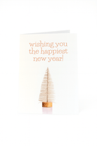 De Matriks Nieuwjaarskaart Wishing You the Happiest New Year! heeft een kleine beige flessenborstelboom en oranje tekst op de voorkant, ontworpen door Ann Berger voor Matriks.