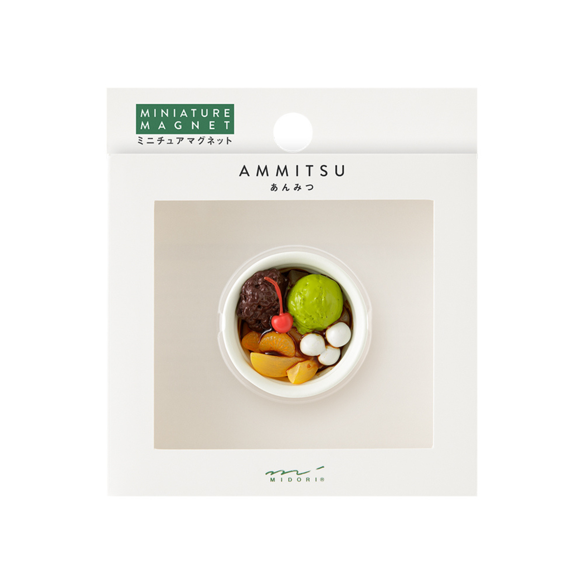 De Midori Miniatuur Magneet Anmitsu heeft een kleine, ronde magneet in de vorm van een Japanse dessertkom met kleurrijke toppings, weergegeven op een witte kaart met het label "Midori" en "Miniatuur Magneet Anmitsu". Ideaal voor fans van Japanse dessertmagneten!.