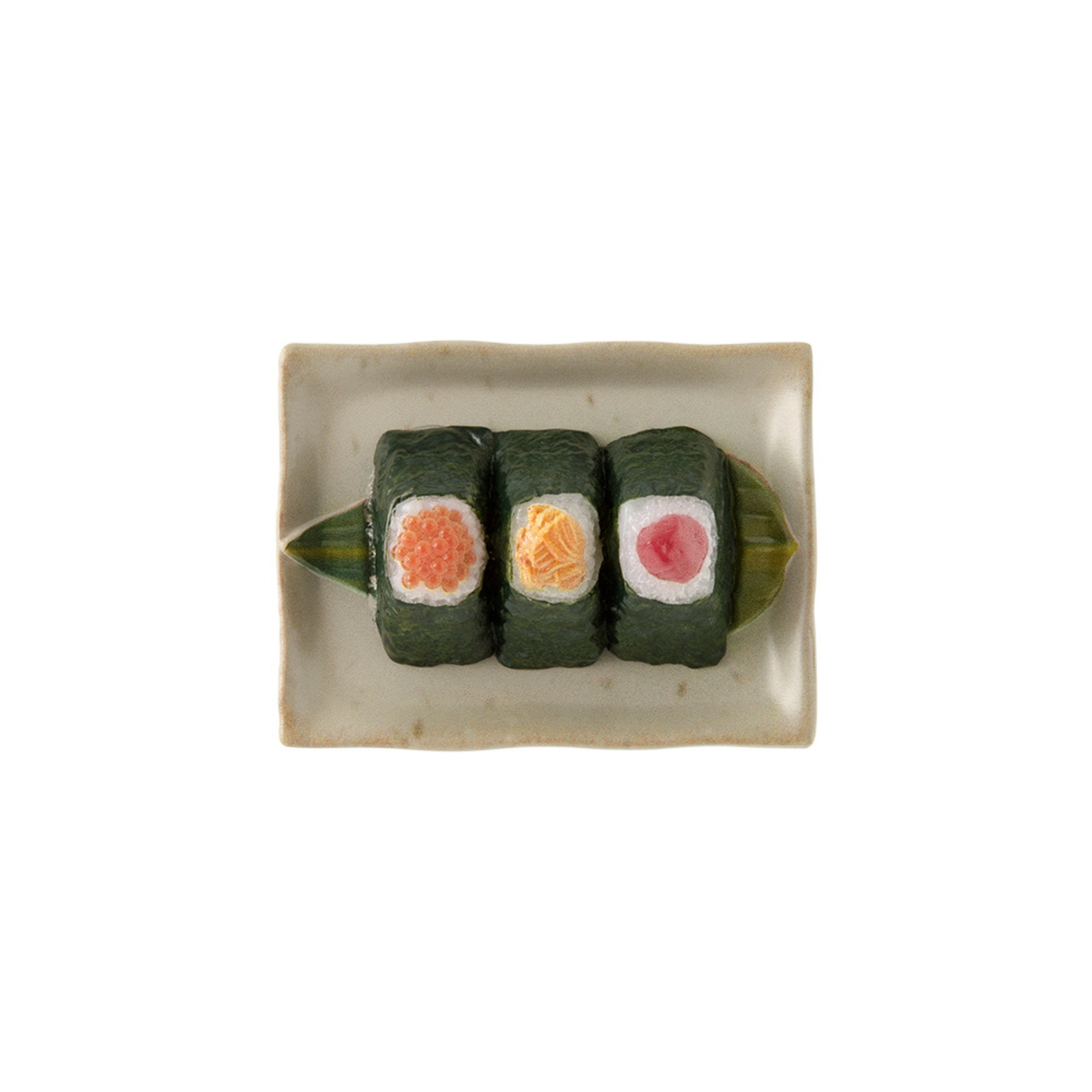 Drie sushi-vormige onigiri magneten van Midori, elk met oranje, gele en roze vullingen, zijn gerangschikt op een keramisch bord met een groen blad - perfect als Japanse rijstbal magneet voor je koelkast: de Midori Miniatuur Magneet Onigiri.