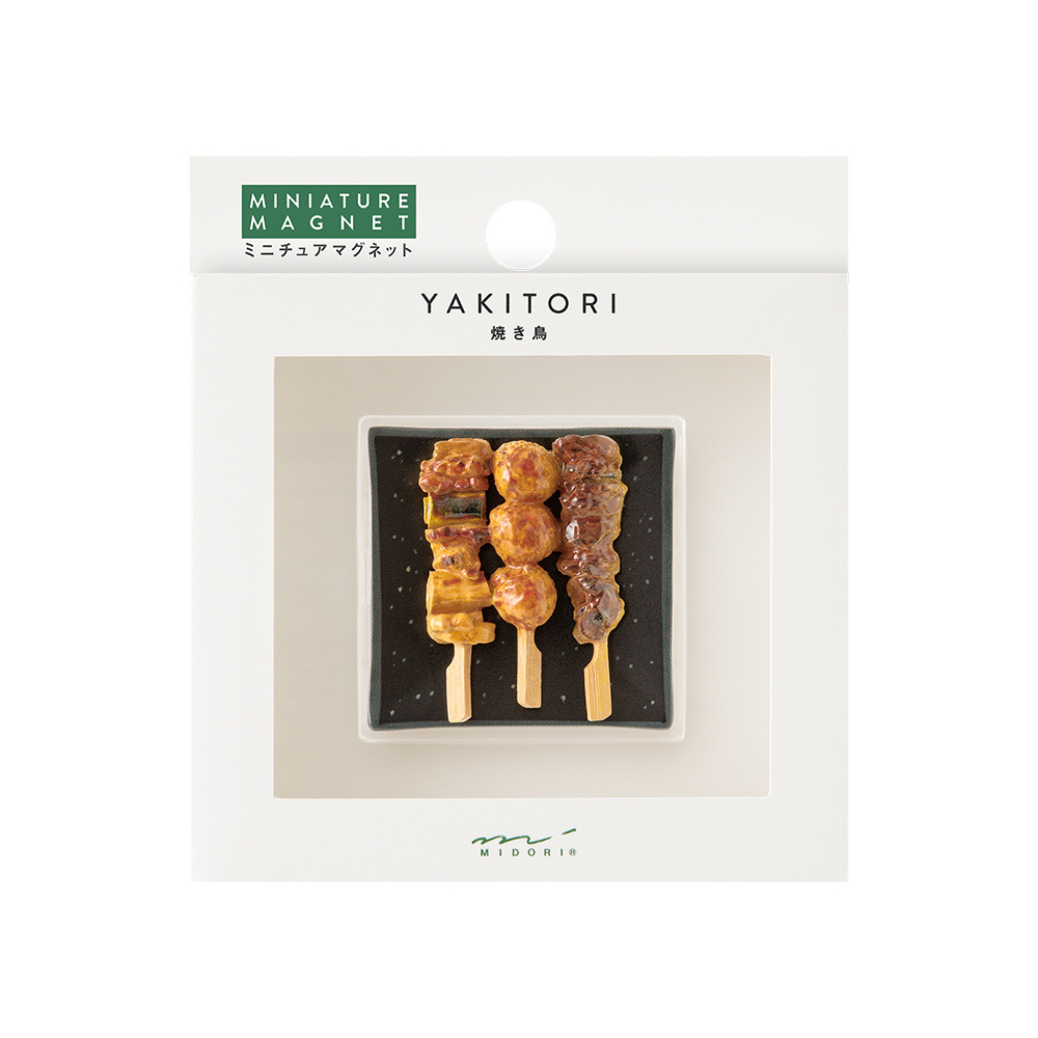 De Midori Miniatuur Magneet Yakitori, vormgegeven als drie spiesjes op een zwart dienblad in YAKITORI gelabelde verpakking met Japanse tekst, is perfect voor fans van Japanse keuken en is afkomstig van het merk Midori.