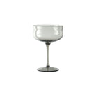 De Paveau Swirl Champagne Coupe Mist Smoke 26 cl van Paveau heeft een enkel transparant grijs glas met een brede, gebogen kom en lange steel, elegant weergegeven op een witte achtergrond.