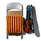 Een metalen klapstoel met het opschrift MUSIC DEPT. en een houten zitting wordt bekleed met een Puebco Draagbaar Kussen Strepen Bordeaux x Mosterd by Puebco voor extra comfort, naast een open vioolkist op een witte achtergrond.