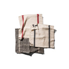 Drie gevouwen Puebco India Theedoek Zwart 60/60 servetten - beige met rode strepen, beige met zwarte strepen en donkergrijs (Theedoek Zwart) met witte strepen - zijn gemaakt van gerecycleerde stoffen in India en liggen op een witte achtergrond.