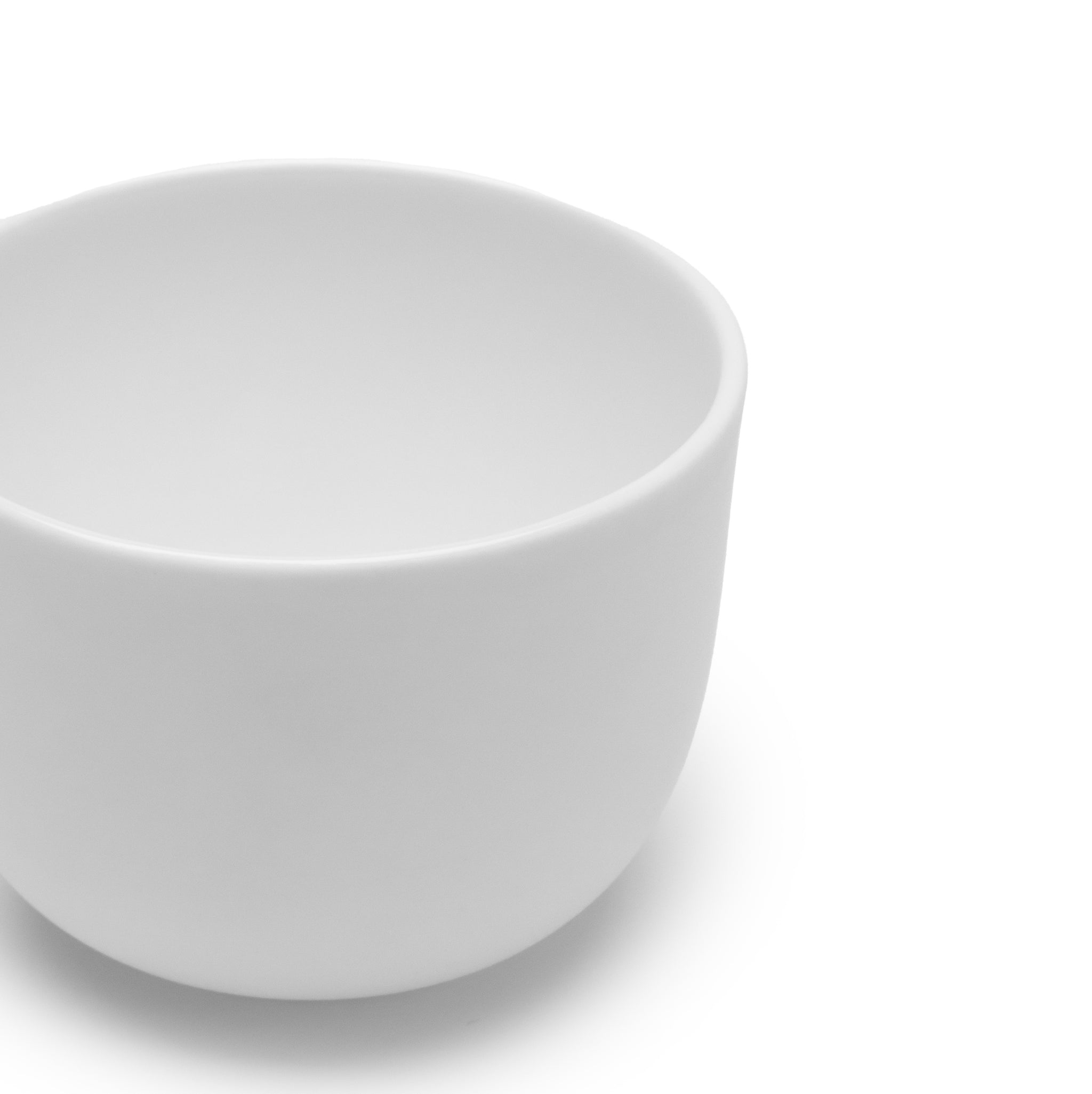 Een effen, witte Serax Base Espresso Kop zonder Oor 10 cl staat op een witte achtergrond, de bovenrand en binnenkant zijn zichtbaar. Het eenvoudige ontwerp weerspiegelt de tijdloze elegantie van de porseleinen stukken uit de Serax collectie.