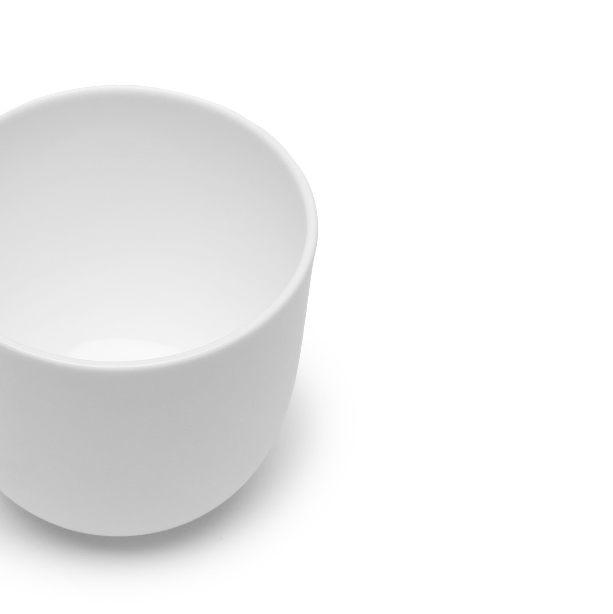 De Serax Base Koffiekop zonder Oor 30 cl, een minimalistische beker van wit keramiek van Serax, wordt van bovenaf weergegeven op een witte achtergrond, waarbij het strakke ontwerp een echo is van traditioneel Chinees porselein.