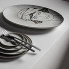 De Serax La Mère Laag Bord Wit D14,5 van Serax heeft een minimalistische elegantie met zijn strakke ontwerp, perfect om te combineren met kleine borden en dessertvorkjes voor een moderne tafelsetting.