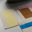 De Suite 702 Badmat Aqua Donkergroen 50/80 van Suite 702, gemaakt van biologisch katoen, heeft een minimalistisch ontwerp met gedurfde strepen in geel, bruin, roze en blauw - een moderne, op Karel Martens geïnspireerde touch voor elke lichtgekleurde vloer.