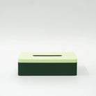 De Wavy Tissuebox Highland Groen/Munt van Wavy Design Studio heeft een rechthoekig, 3D-geprint ontwerp met een lichtgroene bovenkant en donkergroene geribbelde zijkanten, weergegeven op een effen wit oppervlak.