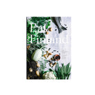 Het Eet Finland Kookboek van Cozy Publishing heeft een omslag met verse vis, kruiden, champignons, sperziebonen, bloemkool en bessen die kunstig zijn gerangschikt op een witte achtergrond.