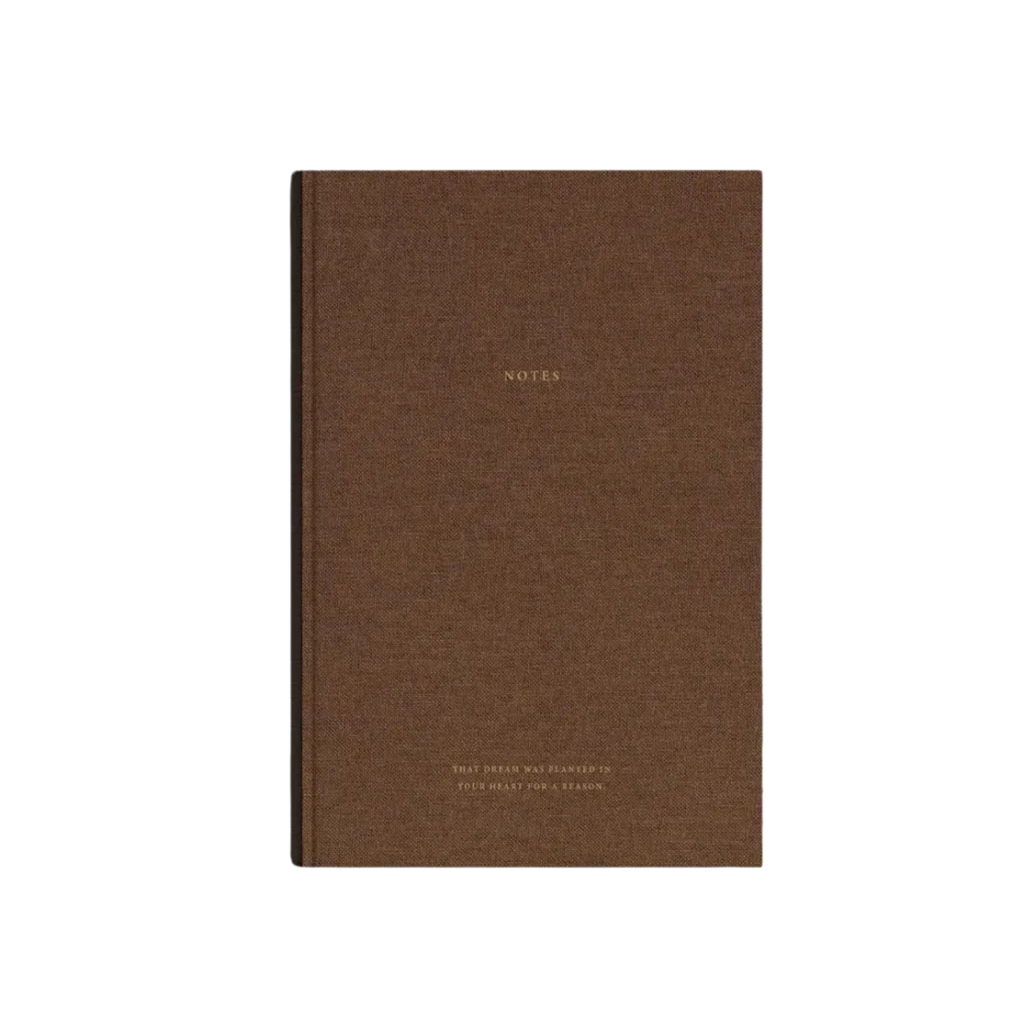 Het Cozy Publishing Notitieboek Bruin Linnen Goud is een bruin hardcover notitieboek van Cozy Publishing, met "NOTES" in goud en kleine gouden tekst eronder, ontworpen door Viola Minerva Virtamo. Het is gefotografeerd op een effen witte achtergrond.