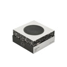 Een moderne vierkante doos toont een cirkelvormig zwart apparaat op het deksel, met het label Jacob Jensen Optical Rookmelder Zwart D10, een strakke zwart-witte rookmelder geïnspireerd op het minimalistische ontwerp van Jacob Jensen.