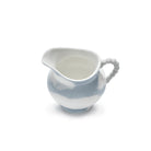 Het Serax Wouters & Hendrix Fête Des Bêtes Melkkannetje Lichtblauw is een kleine keramische kan in lichtblauw en wit met een kralenhandvat, tegen een effen witte achtergrond.