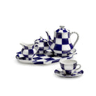 De Serax Wouters & Hendrix Fête Des Bêtes Theepot Blauw Wit heeft een gedurfd blauw-wit dambordpatroon, netjes gerangschikt met bijpassende creamer, suikerpot, dienblad, theekop en schotel tegen een witte achtergrond.