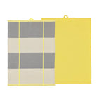 Er worden twee rechthoekige Södahl Blocks Theedoek Geel 2 st. getoond: een effen gele en een met brede grijze en beige strepen met dunne gele lijnen. Beide katoenen doeken hebben een klein ophanglusje aan de bovenkant.