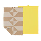 Twee Södahl Twist Theedoek Taupe theedoeken liggen plat op een witte ondergrond. Ze zijn elk voorzien van een geometrisch crèmepatroon, een label en een ophanglus - ideaal voor een Scandinavische keukenstijl.