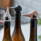 Een selectie wijnflessen wordt aangevuld met de Zone Denmark Rocks Wijn Stopper Warm Grijs, een elegant accessoire dat hun rijke smaken bewaart.